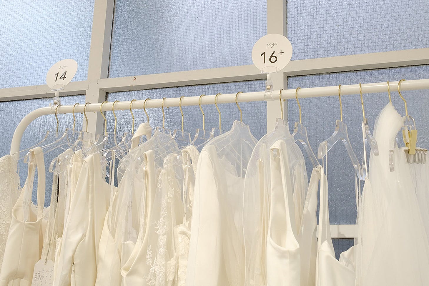Bridal dresses hang on a rack.